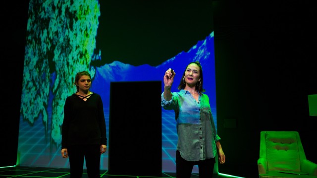 Katja (Emily Radosevich, left) shows Naomi (Charisse Loriaux) the game she is creating.