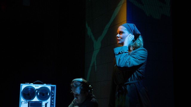 Government agents (Griffin O'Connor and Wera von Wulfen) listen in on conversations.